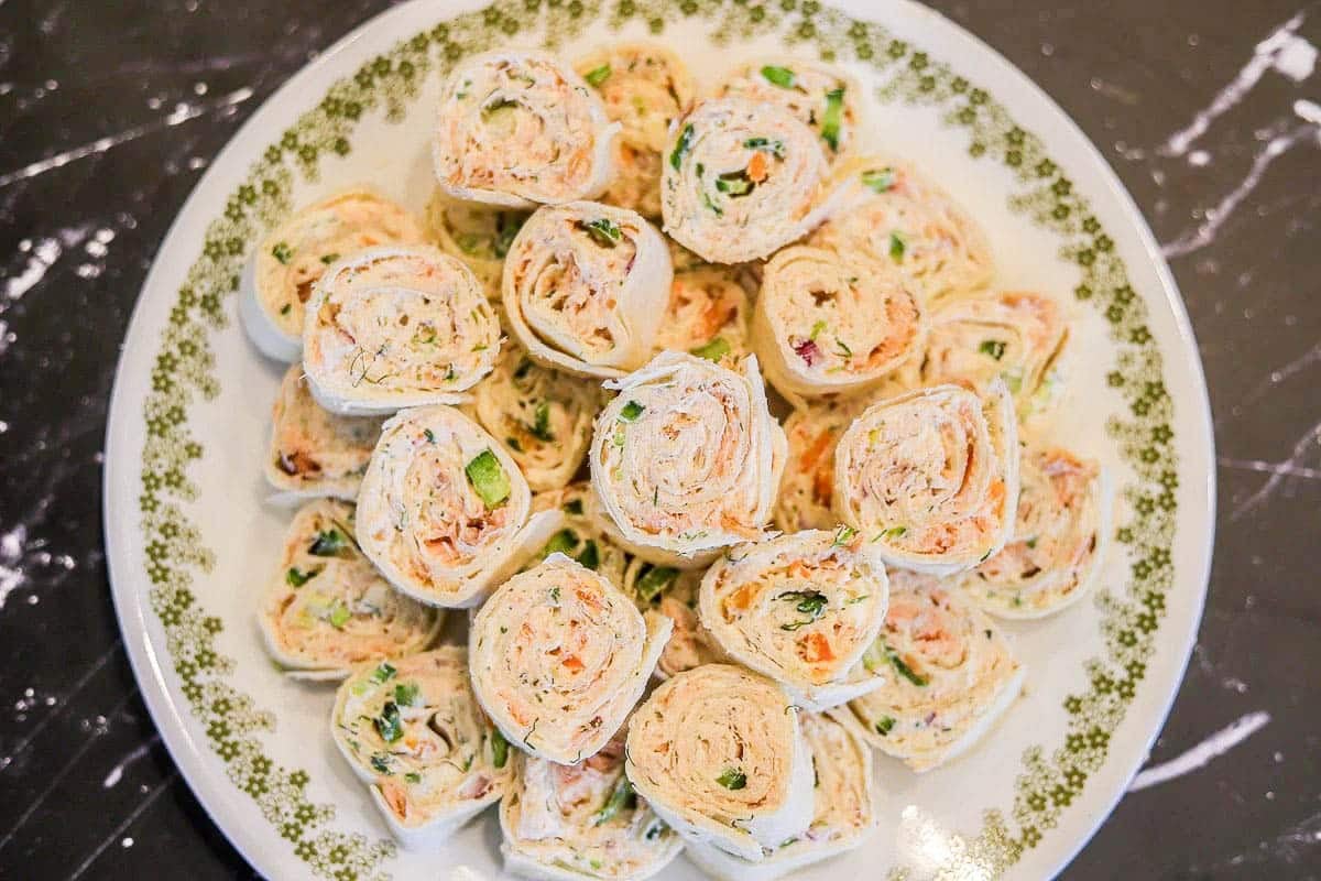 smoked salmon pinwheels on a plate.
