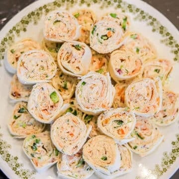 New Years eve appetizers: salmon pinwheels on a white plate.