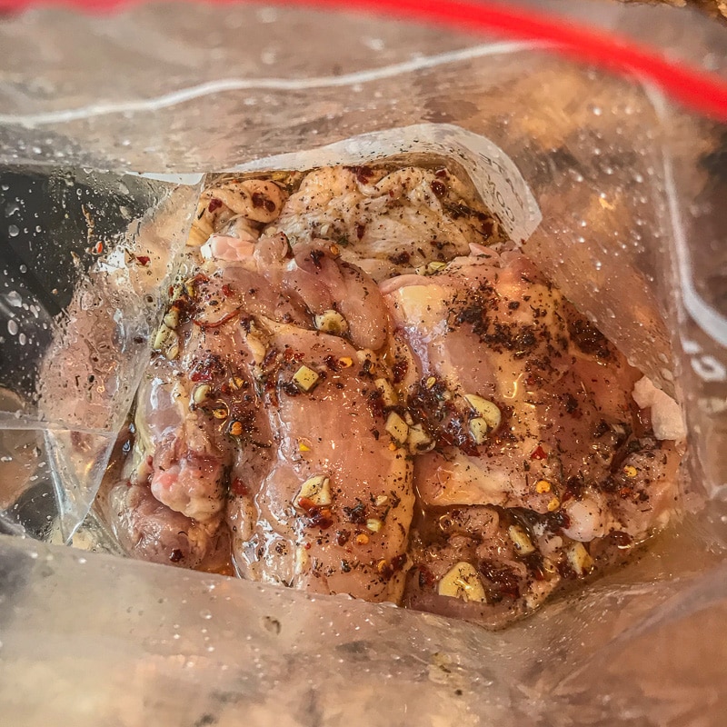 chicken marinating in a plastic bag