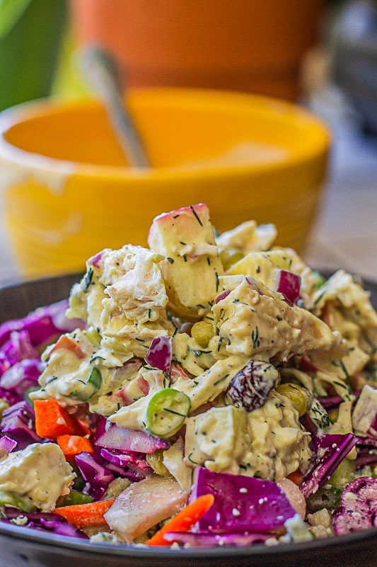 chicken salad in a blue bowl with a yellow bowl behind it