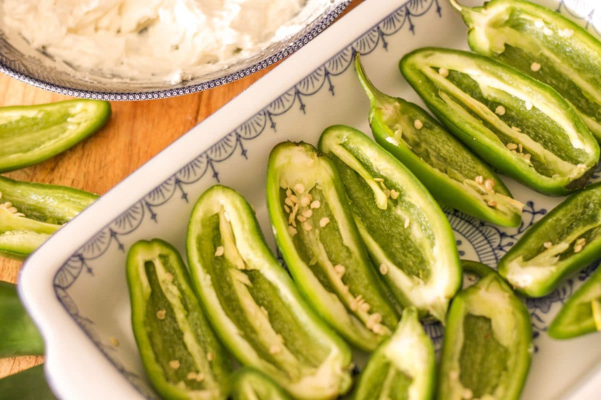 jalapeños peppers sliced in half in a glass dish