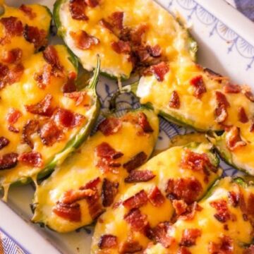 jalapeno poppers on a white dish that's sitting on a checkered orange colored kitchen towel
