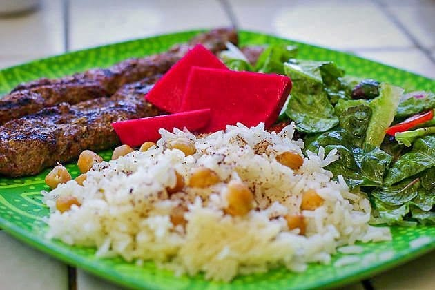 chickpea rice on a plate with kabobs