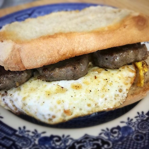 egg and sausage sandwich on a blue willow plate