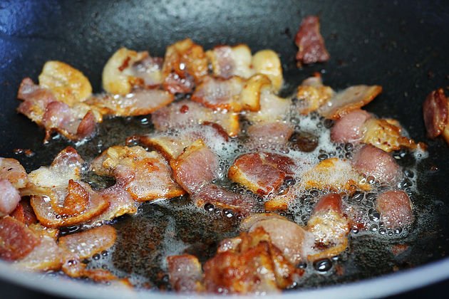 bacon being fried in a pan