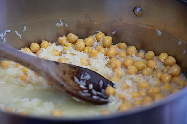 chickpea rice being stirred with a wooden spoon