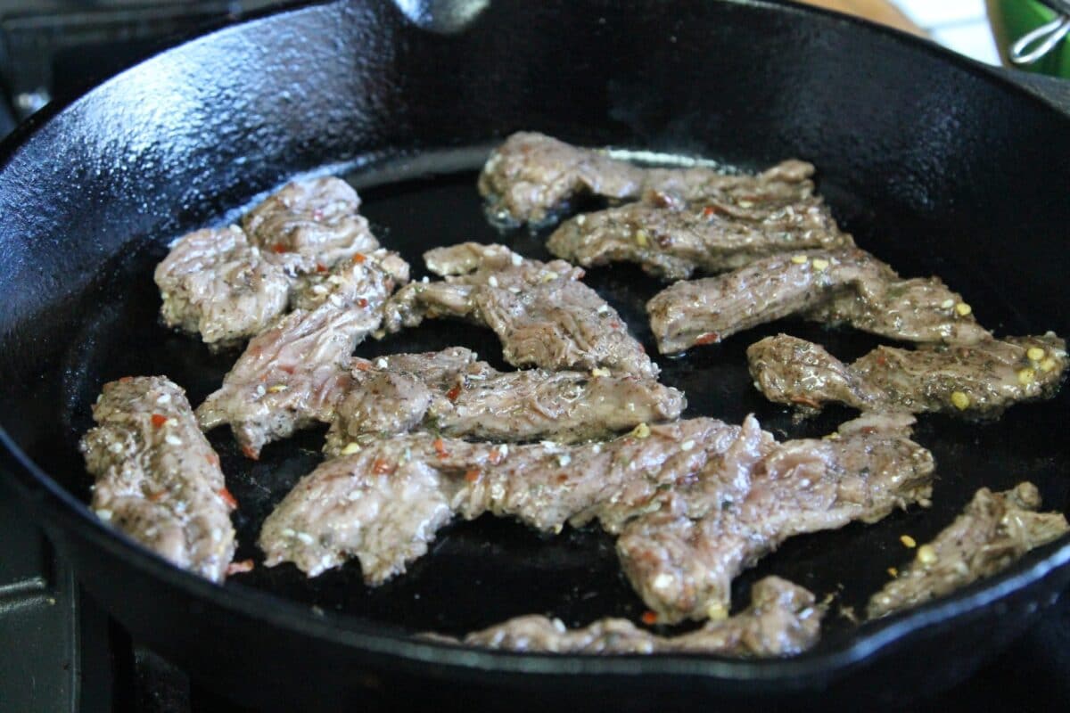 meat being cooked in a castiron pan