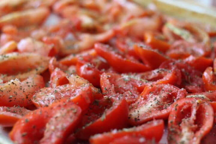 sliced tomatoes with herbs sprinkled on them