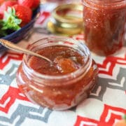 strawberry fig jam in a jar on a red and gray dishtowel