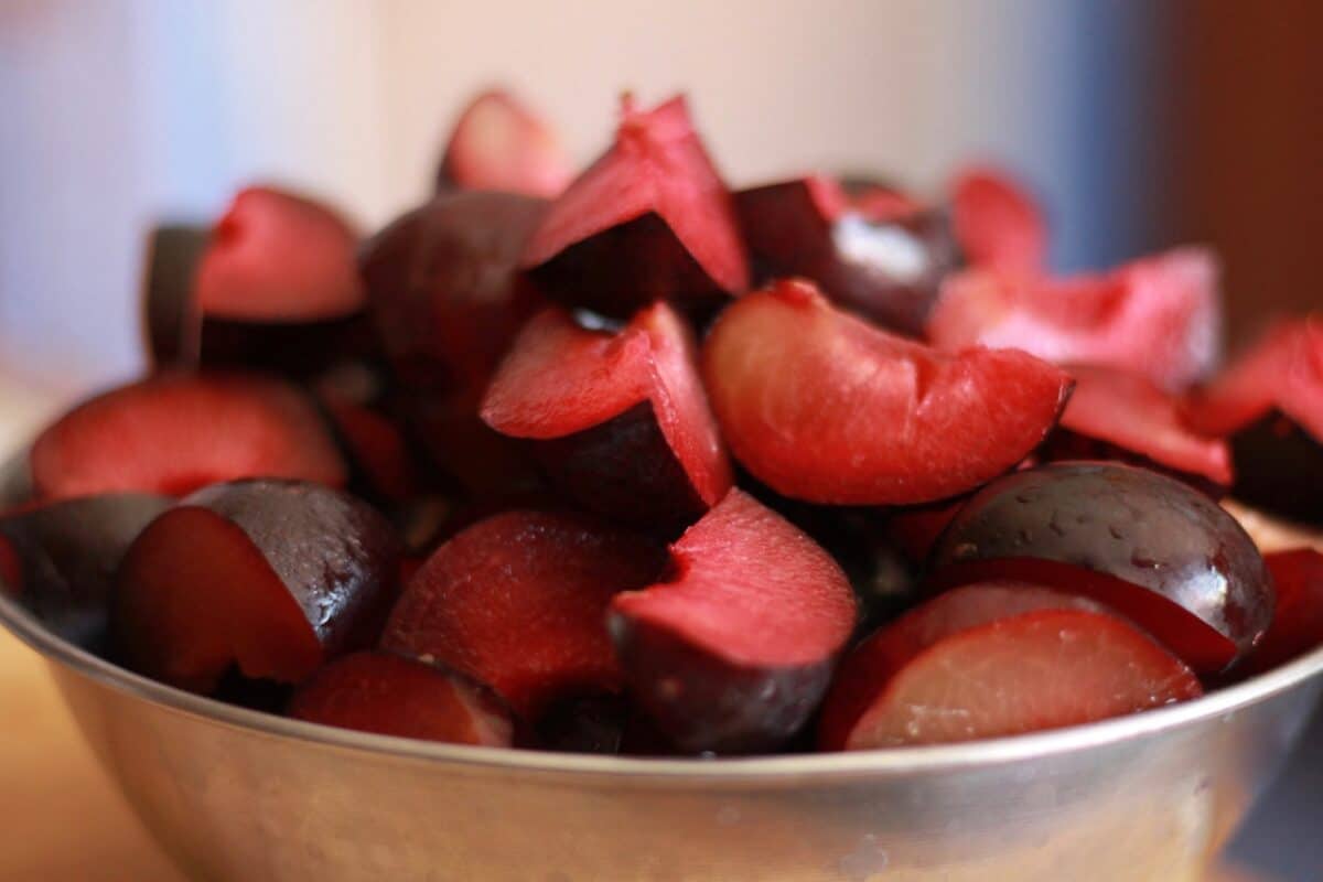 chopped plums ina sliver bowl