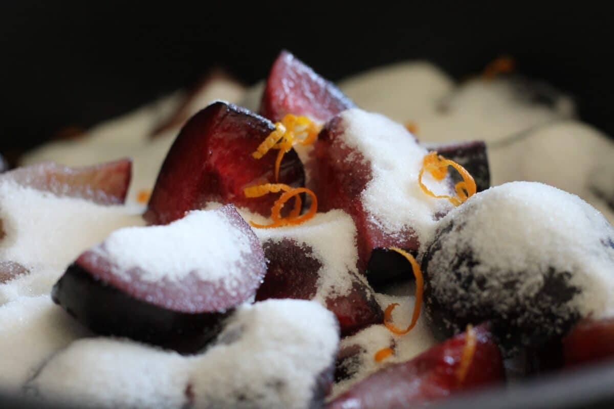 chopped plums with sugar and orange zest over them 