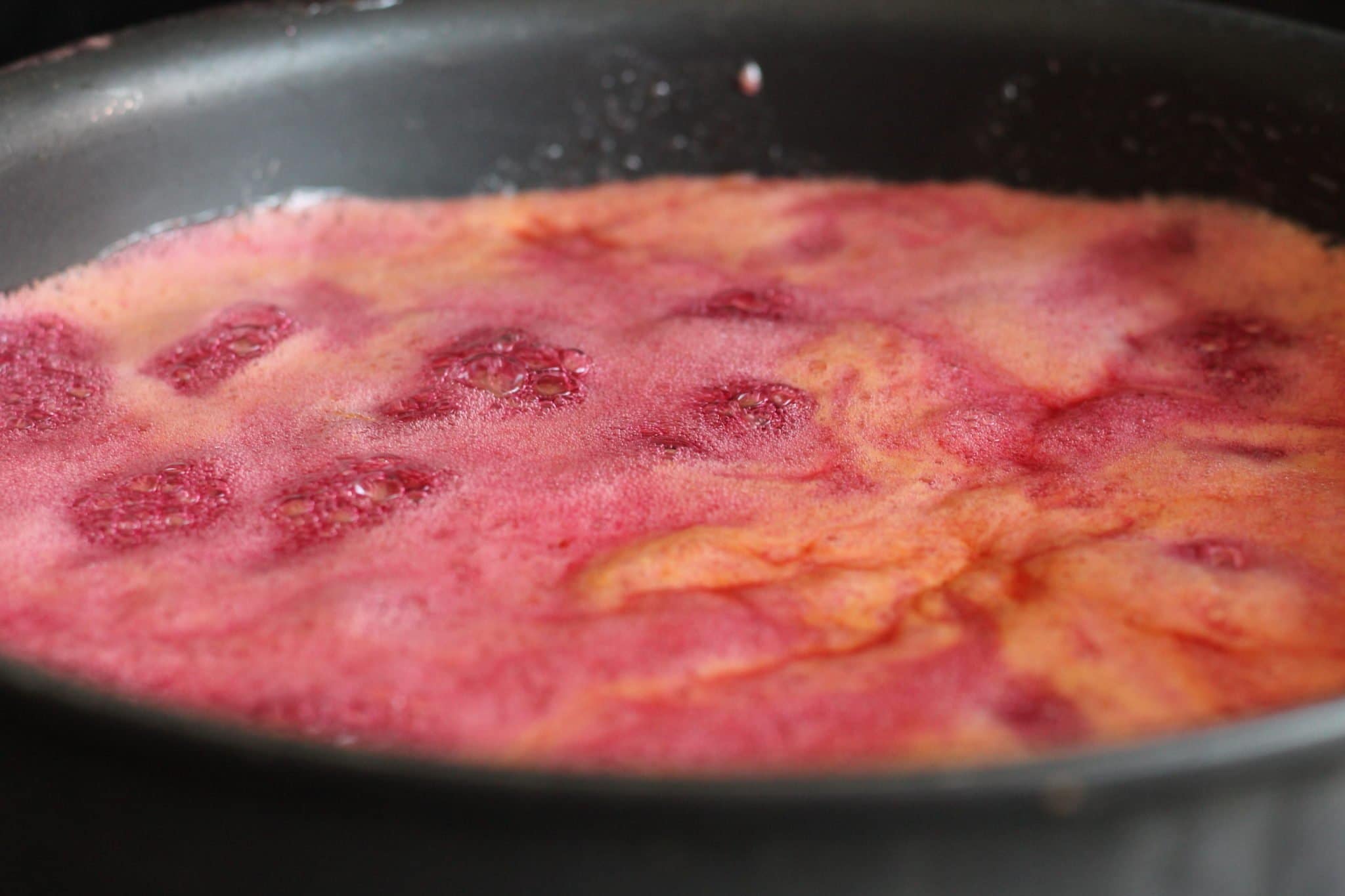 plum preserves cooking in a Dutch oven