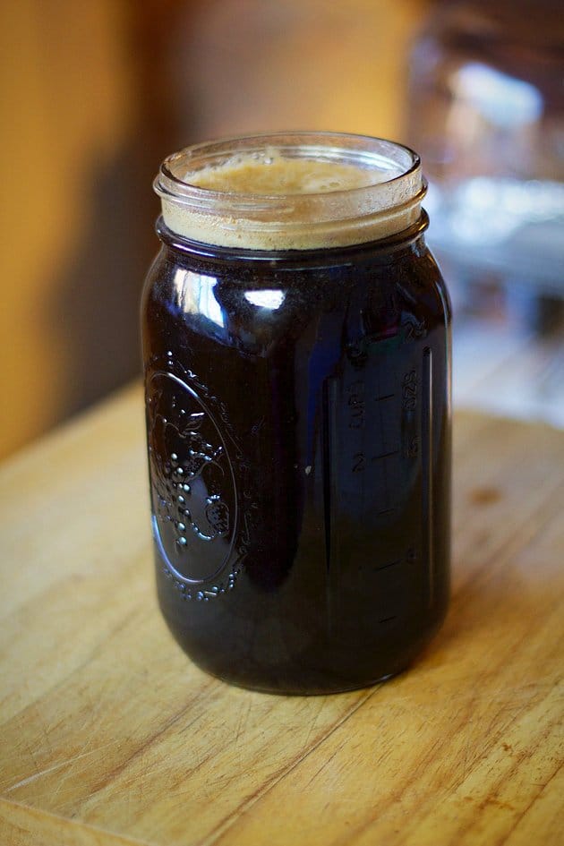 tamarind syrup in a large jar on a cutting board