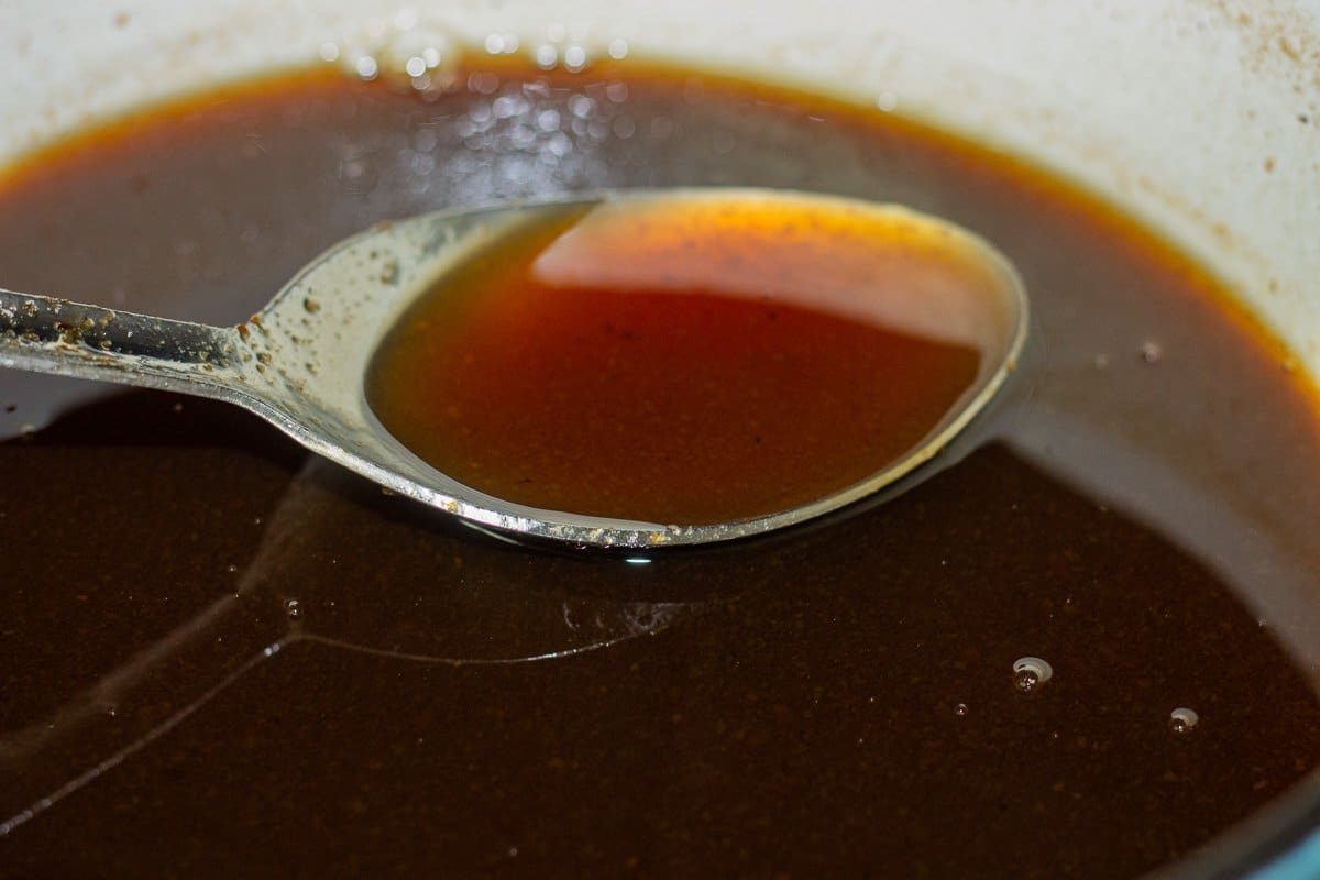 tamarind syrup in a pot being labeled by a large spoon