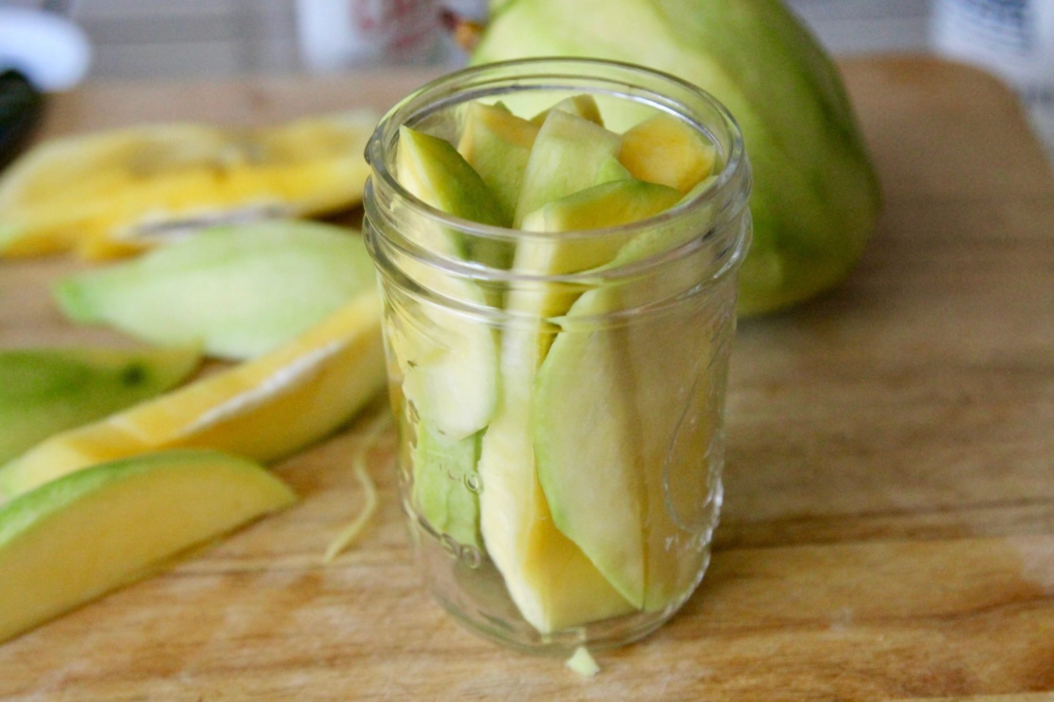 sliced mango in a jar with more on the side
