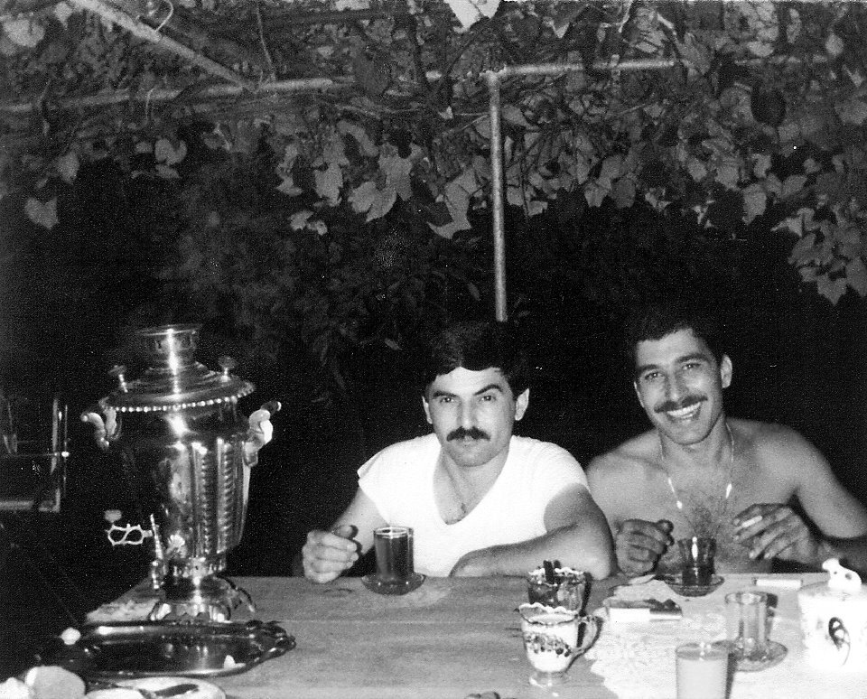 samovar tea on a table with two men sitting there