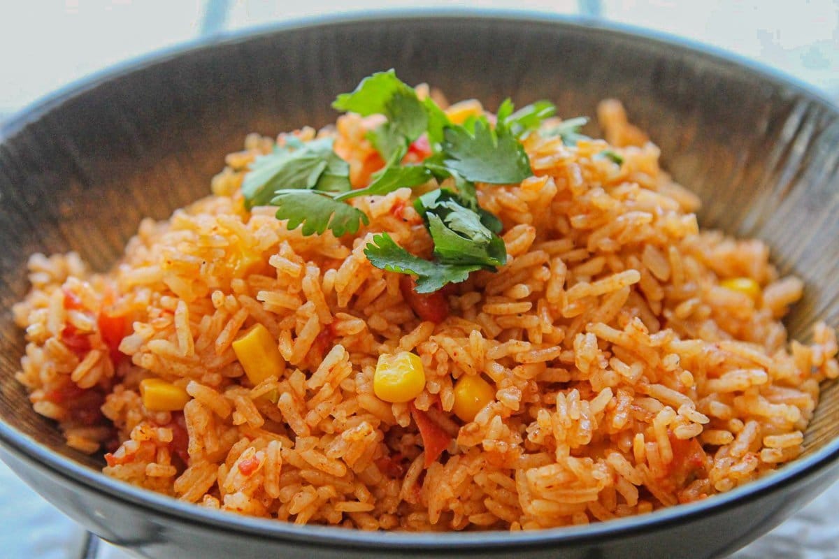 spanish rice topped with cilantro in a brown bowl