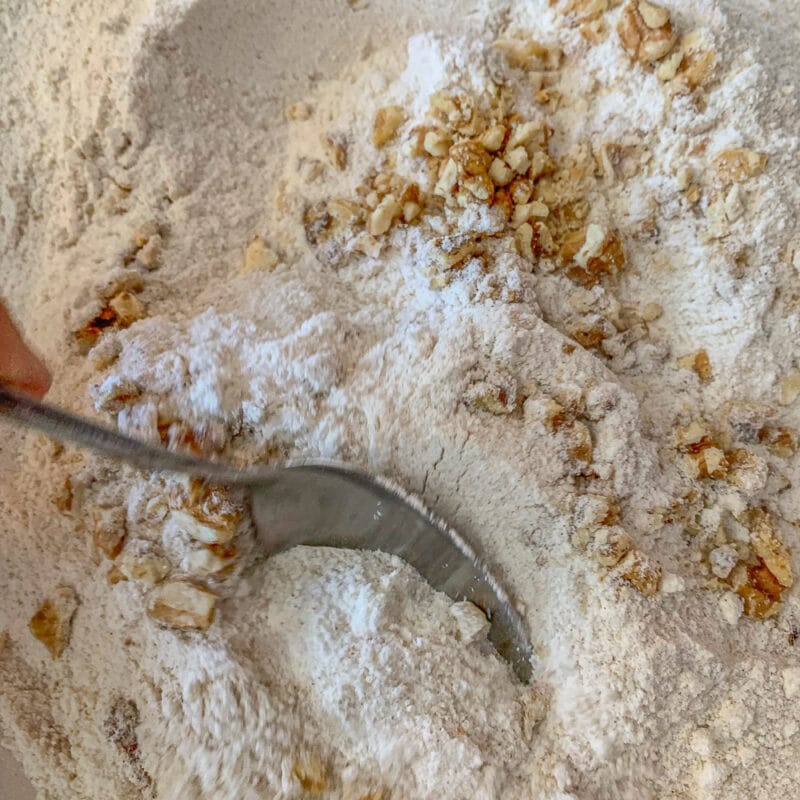 mixing nuts in with flour in a bowl