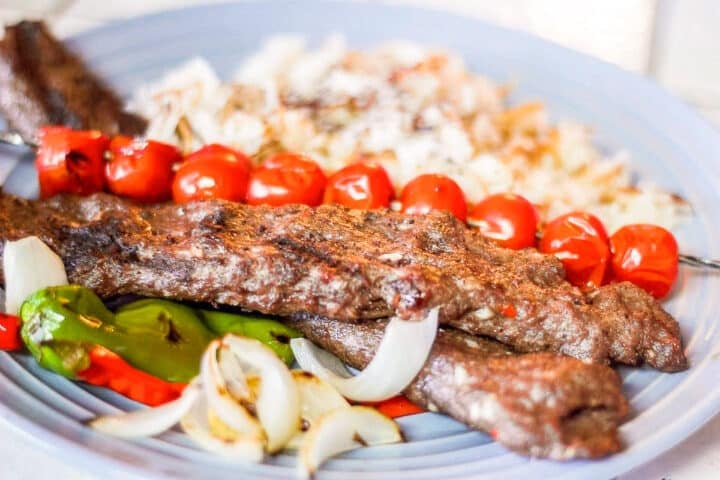 goat kebabs over a bed or rice.
