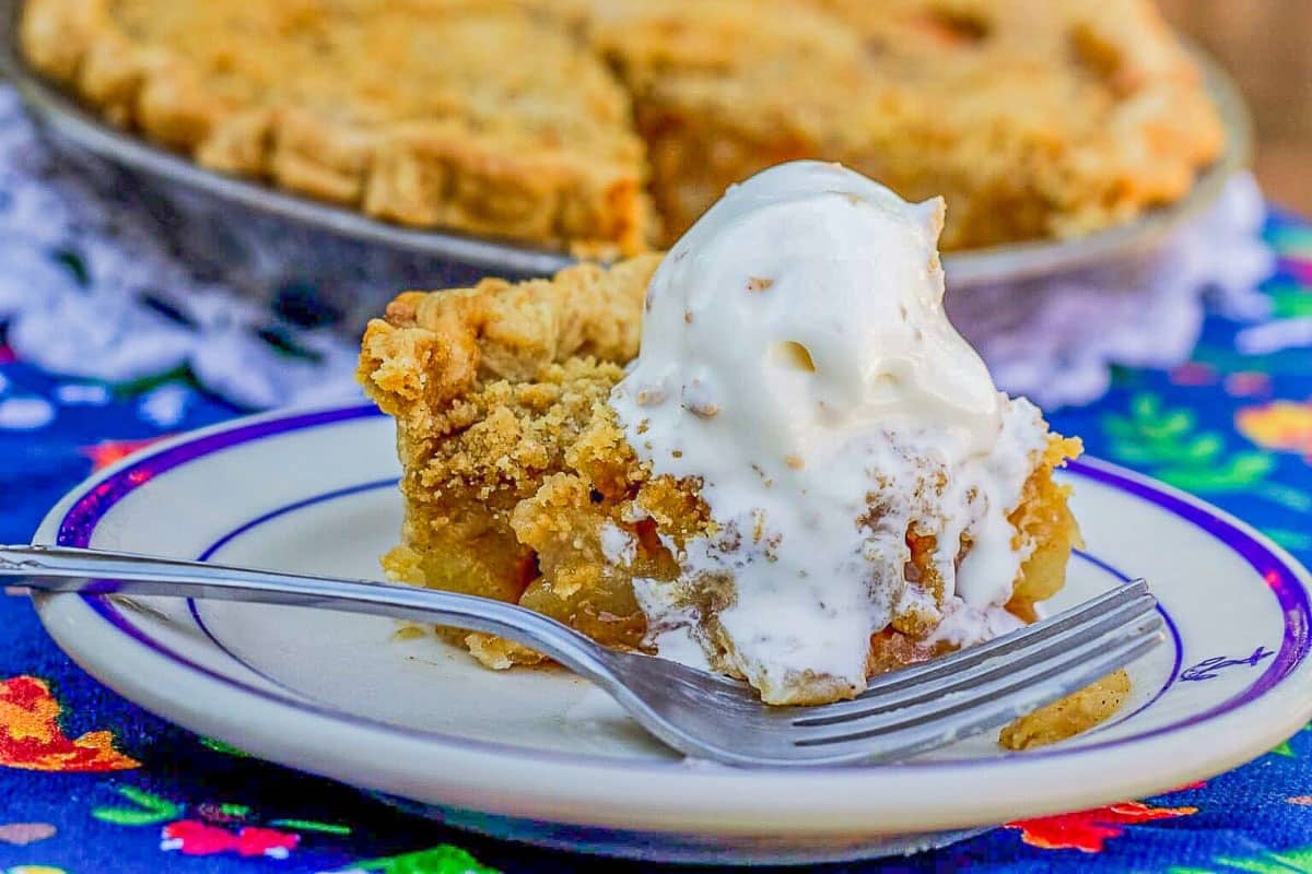 a slice of pear pie with vanilla ice cream on a white plate