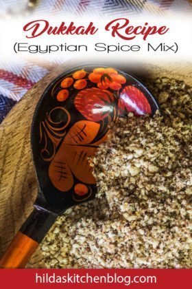 dukkah spice blend being spooned with a black and orange spoon