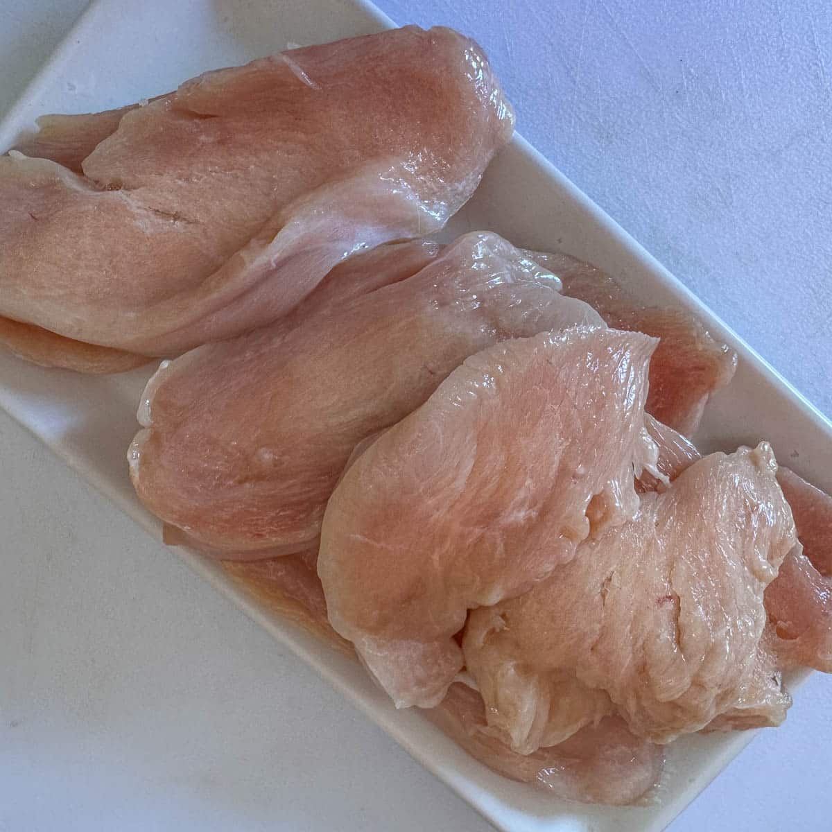 sliced chicken cutlets on a white plate