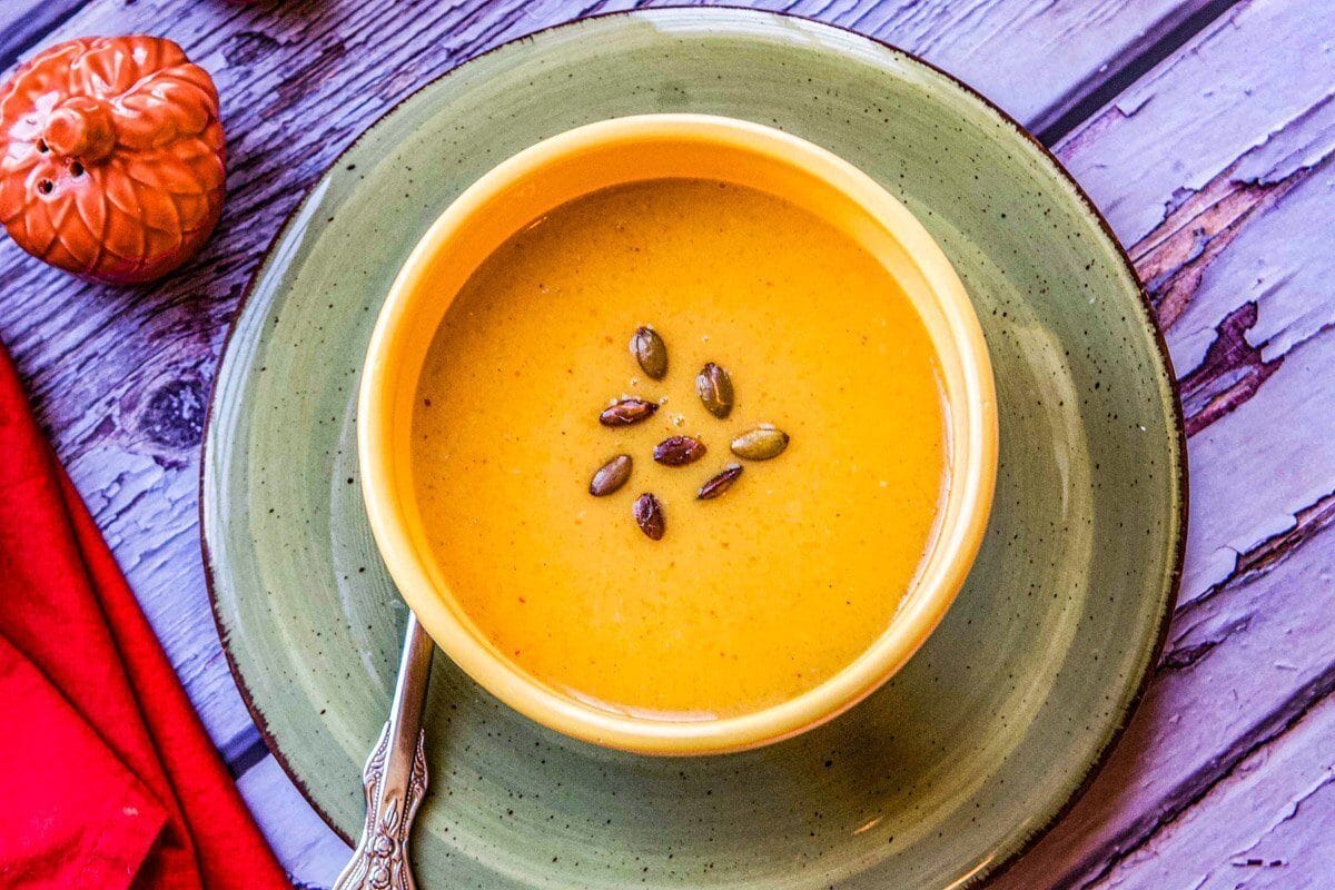 roasted pumpkin soup in a bowl with a red napkin and salt shaker