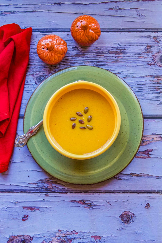 pumpkin soup with salt pepper and a red napkin on the side