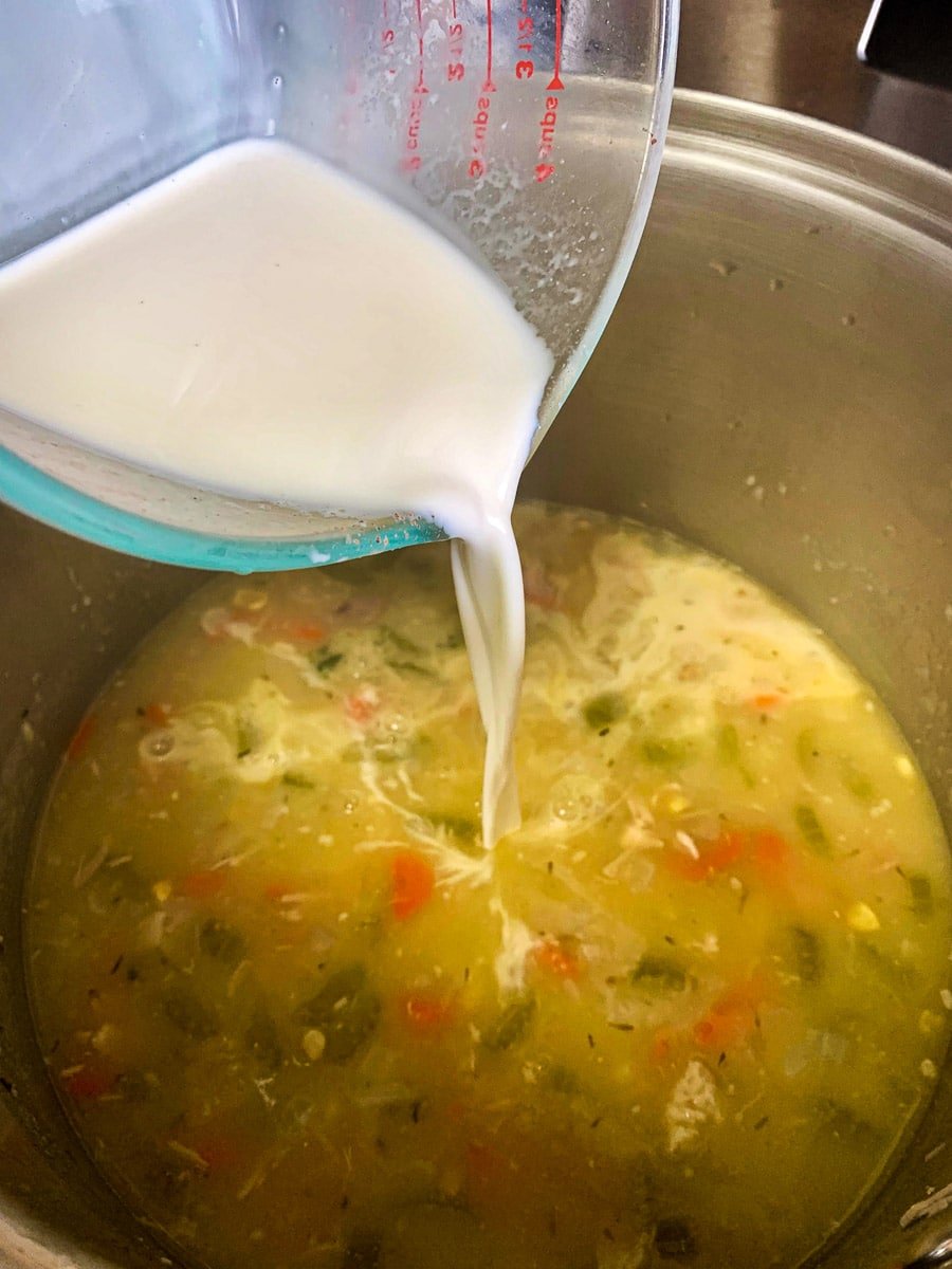 milk being poured into soup