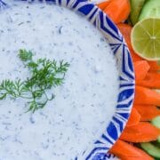 yogurt dip in a bowl, with carrots and a lime wedge