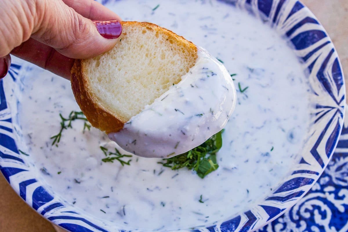 dipping bread into yogurt sauce for chicken