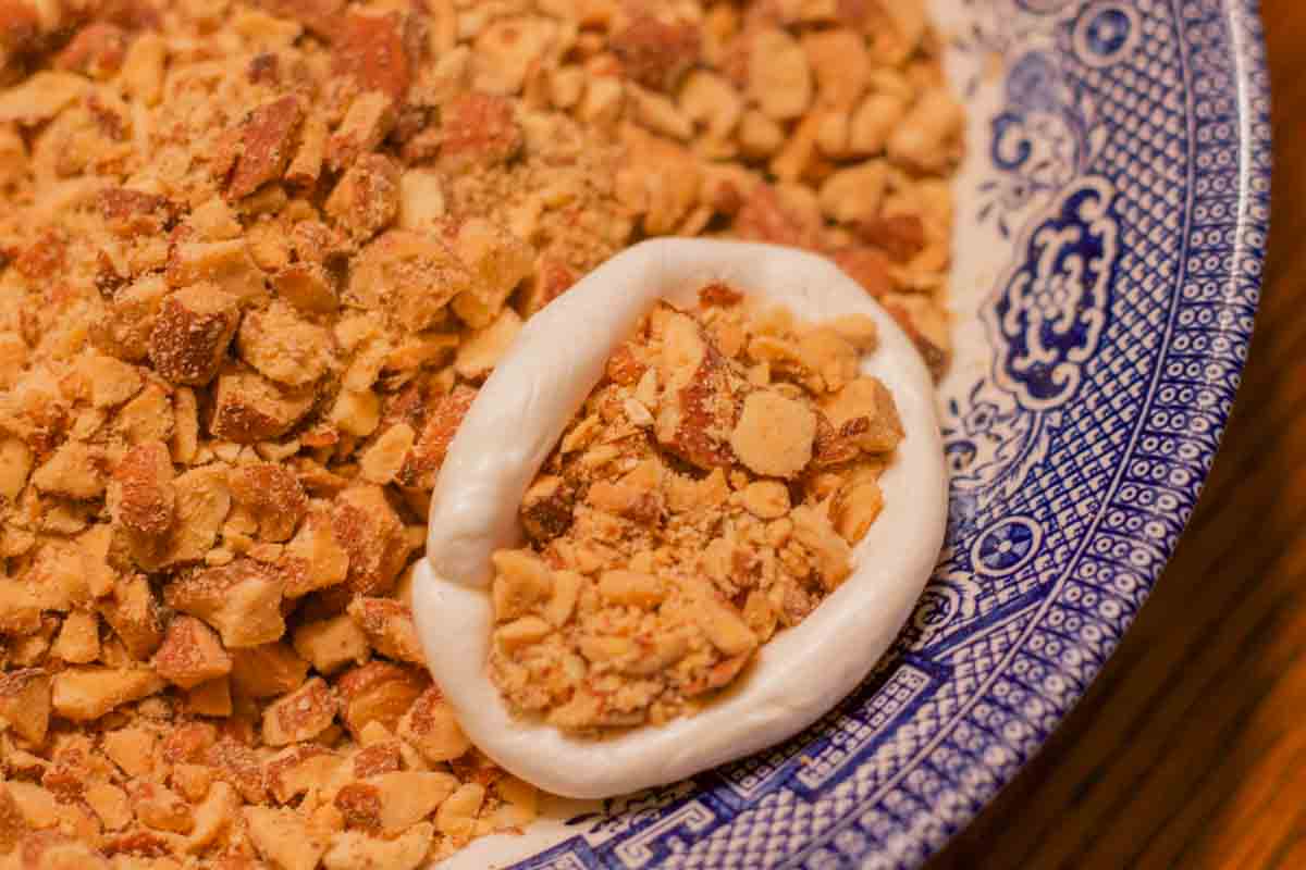 nougat stuffed with nuts on a blue plate with chopped nuts