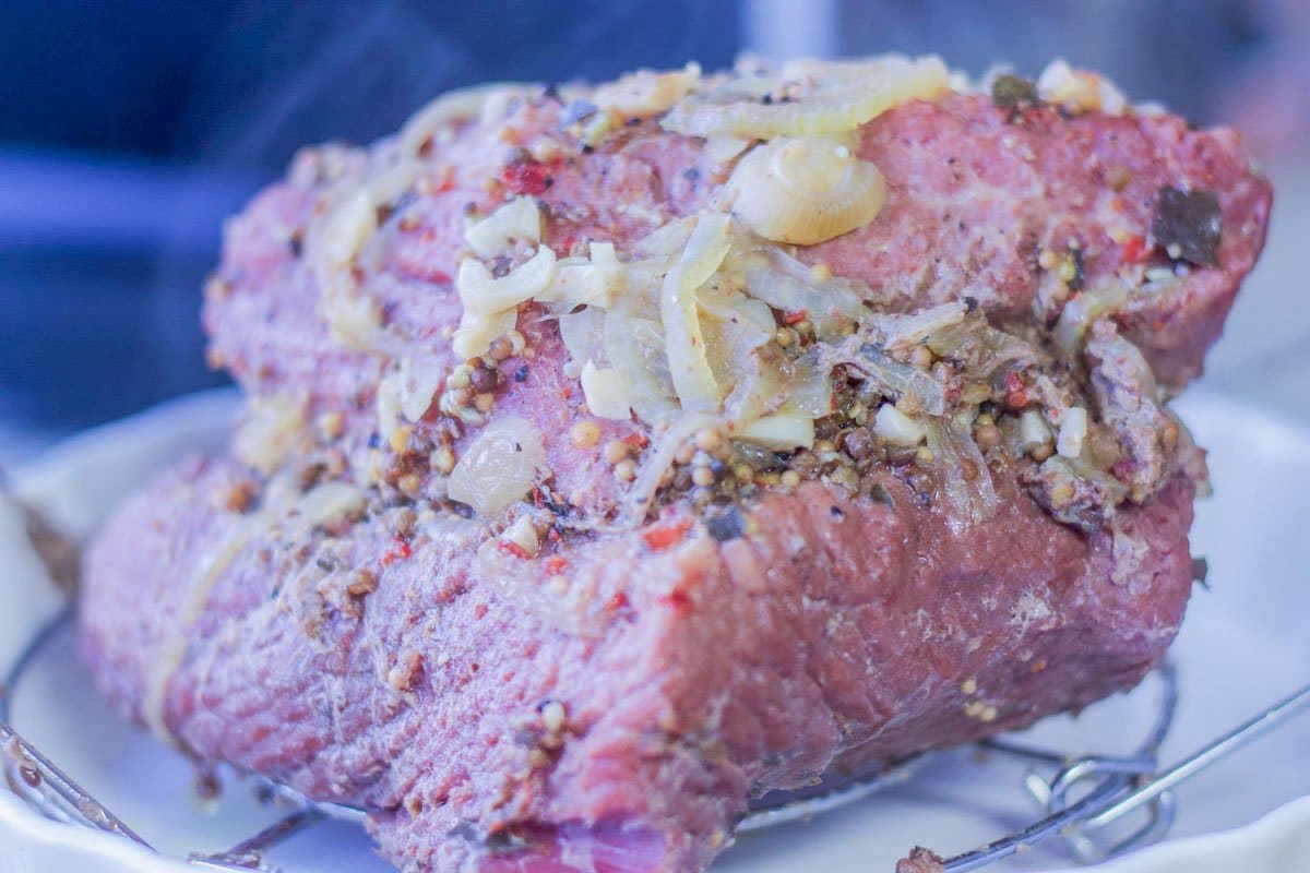 cooked corned beef brisket covered with spices, onions, and garlic