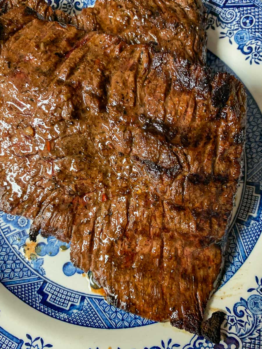 juicy carne asada on a blue and white plate