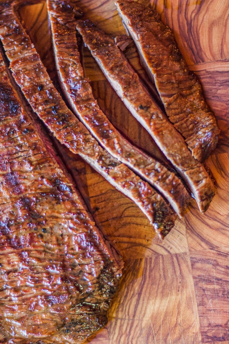 sliced carne asada, on a cutting board