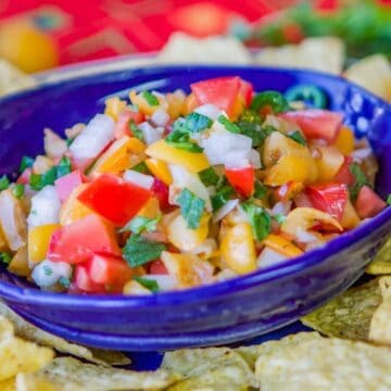 loquat salsa in a blue bowl with tortilla chips