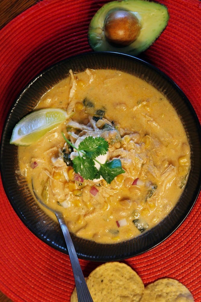 cream cheese chicken chili with avocado and cilantro and chips