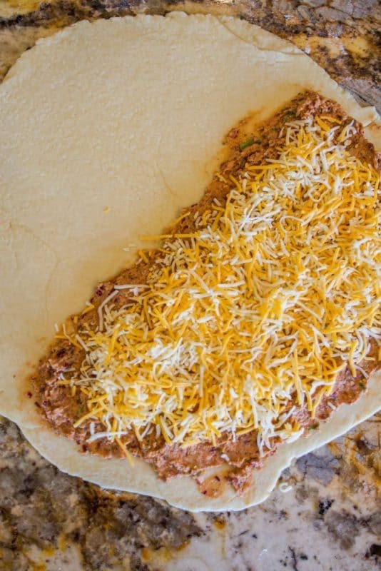bean and cheese on a flat round piece of dough