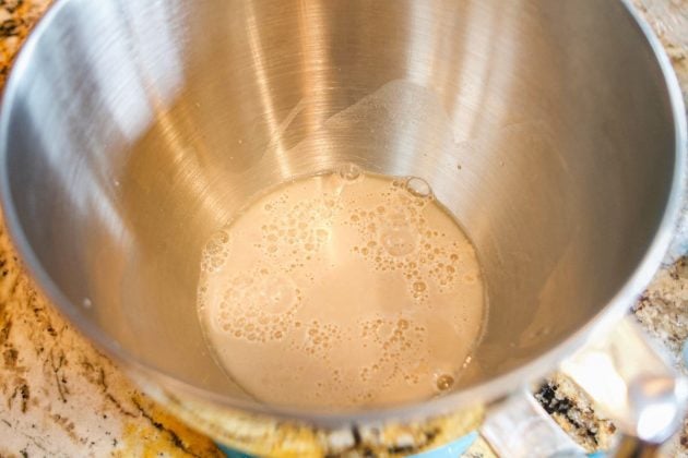 yeast in warm water in a silver mixing bowl.