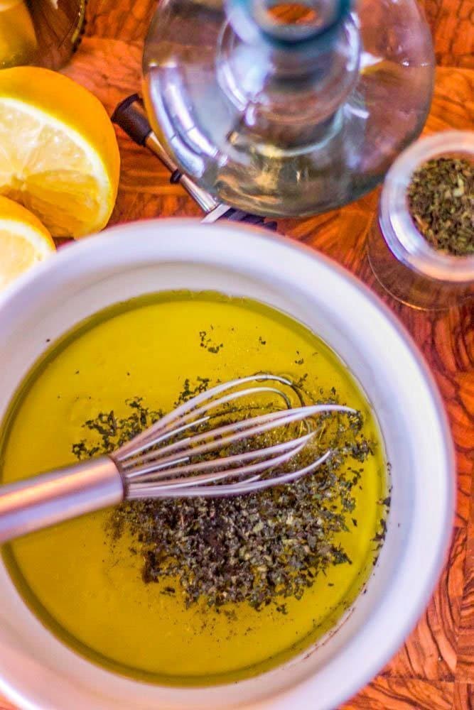 salad dressing with whisk in white bowl