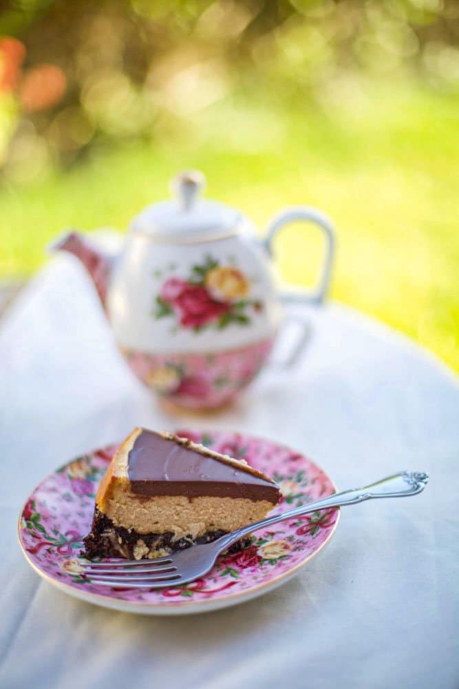  a slice of cake on a plate with a teapot behind it