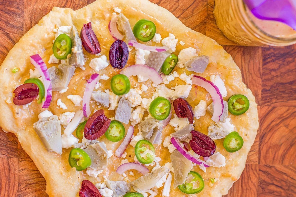 naan bread with peppers, onions, olives, and cheese