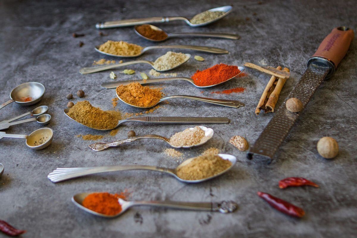 baharat spice blend in spoons on counter