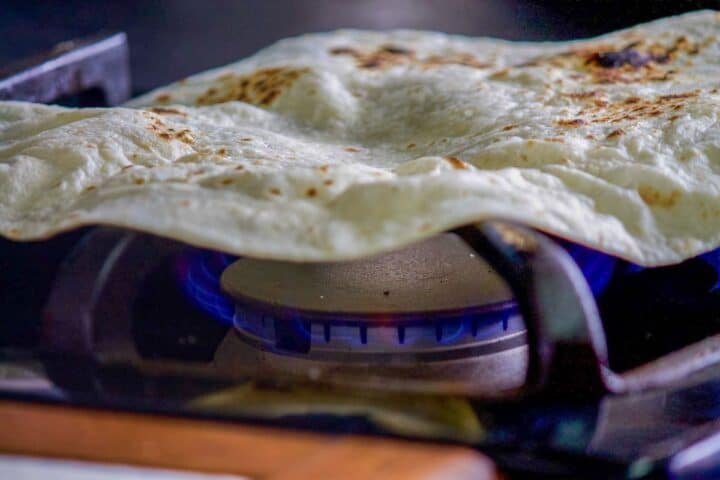 tortilla being toasted over a burner