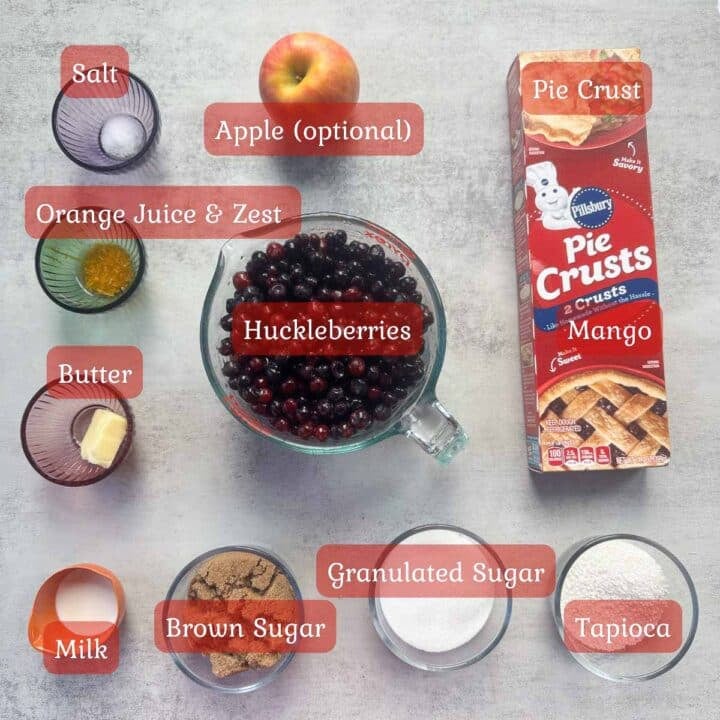 huckleberry pie ingredients including huckleberries, pie crust, apple, sugar, spices.