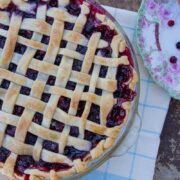 huckleberry pie with a lattice top o na napkin with a plate on the side
