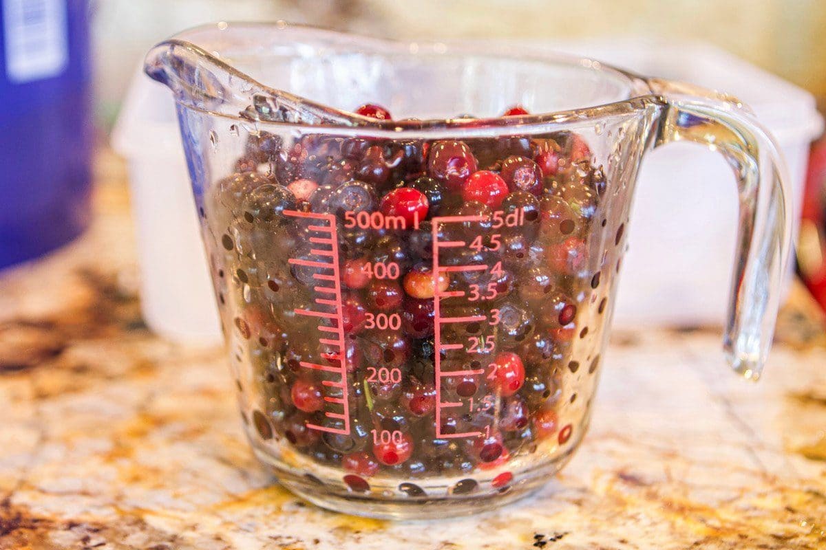 a measuring cup with huckleberries