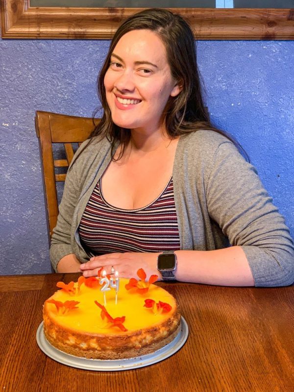 birthday girl with cheesecake on the table in front of her.