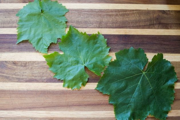 3 grape leaves on a cutting board