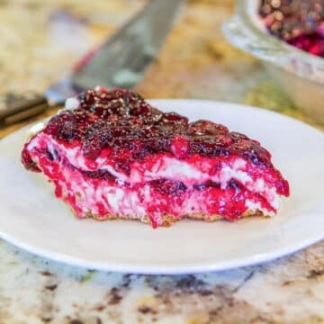 a slice of berry cheesecake on a white plate